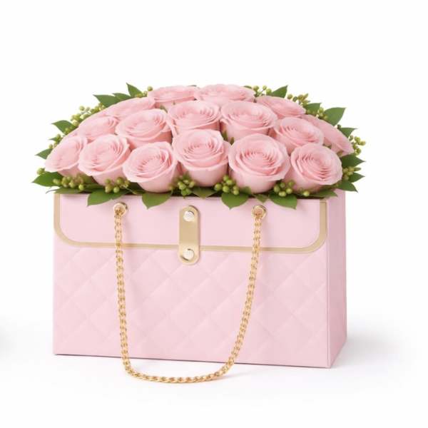 Pink roses arranged in a pink box with a gold chain handle