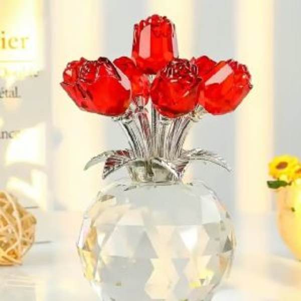 Five red rose-shaped decorative stems in a clear faceted vase