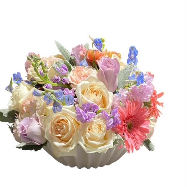 Pastel mixed flower arrangement in a white bowl vase