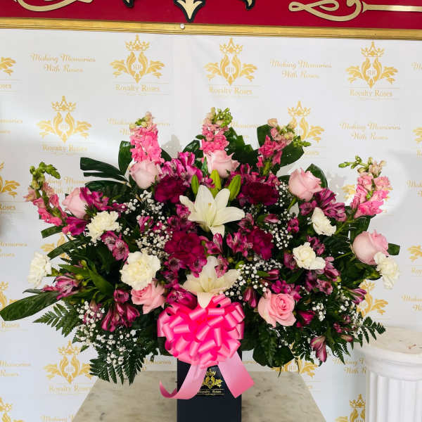 Large pink and white floral arrangement in a black box with a ribbon bow