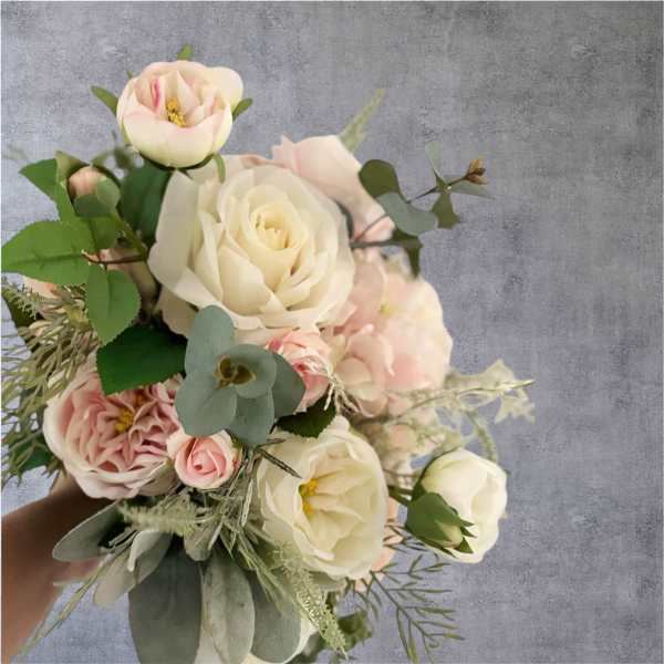 Bouquet of blush and ivory roses with greenery
