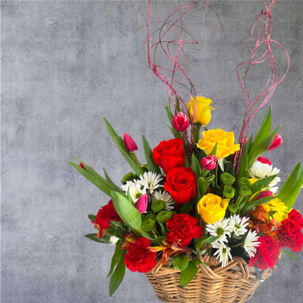 Basket arrangement of red and yellow roses with daisies and tulips