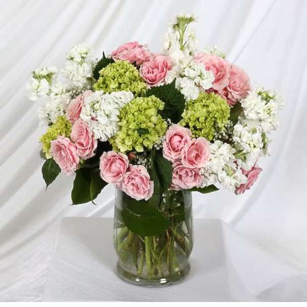 Pink and white flowers arranged in a glass vase