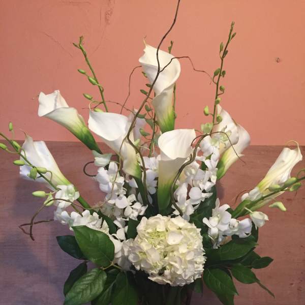 White calla lilies and hydrangea in a tall vase arrangement