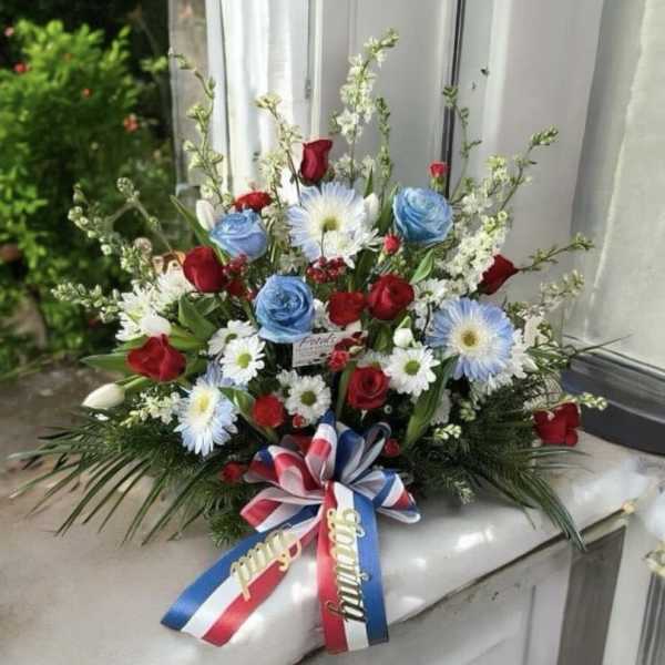 Red and blue floral spray with ribbon bow