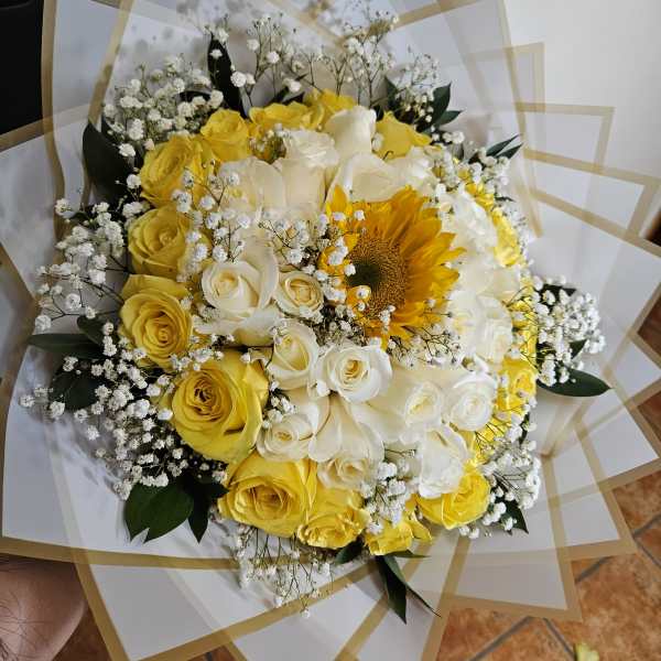 Bouquet of yellow and white roses with a sunflower and baby's breath