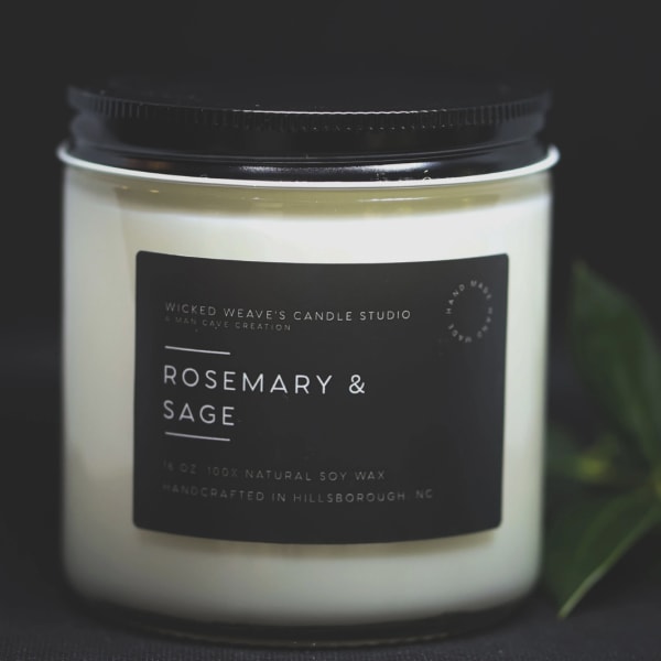 Jar candle labeled rosemary and sage with a black lid