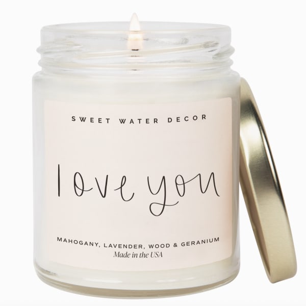 Glass jar candle with a gold lid and "love you" label