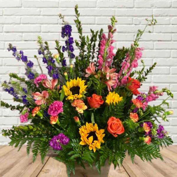 Large mixed flower arrangement with sunflowers, roses, and pink and purple blooms