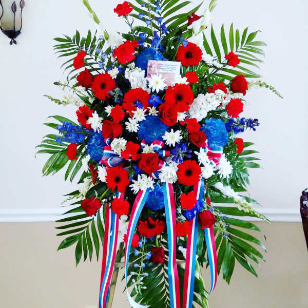 Large standing floral spray with red, white, and blue flowers