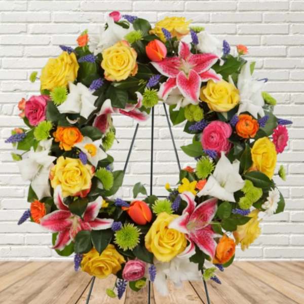 Colorful floral wreath with roses and lilies on a metal stand