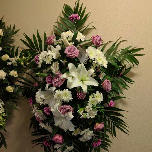 Standing floral spray with white lilies, pink roses, and white daisies