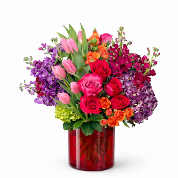 Mixed bouquet of roses and tulips in a red glass vase