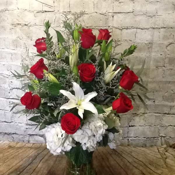 Red roses and white lilies in a clear glass vase
