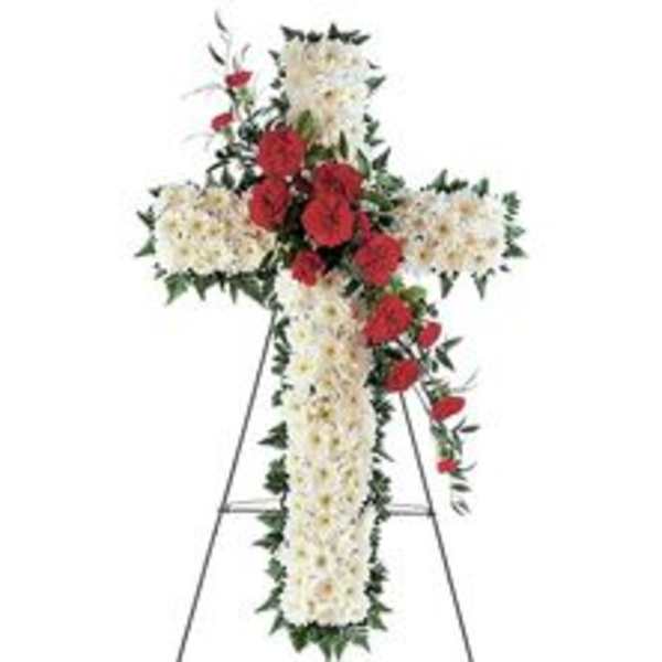 Cross-shaped floral funeral spray with red and white flowers on a stand