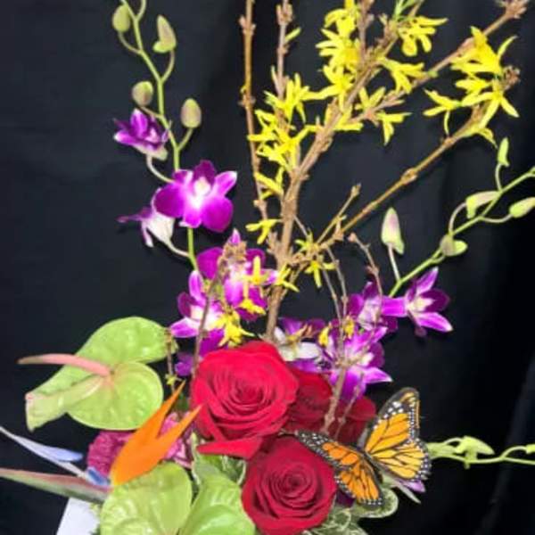 Bouquet with red roses, purple orchids, and a butterfly accent
