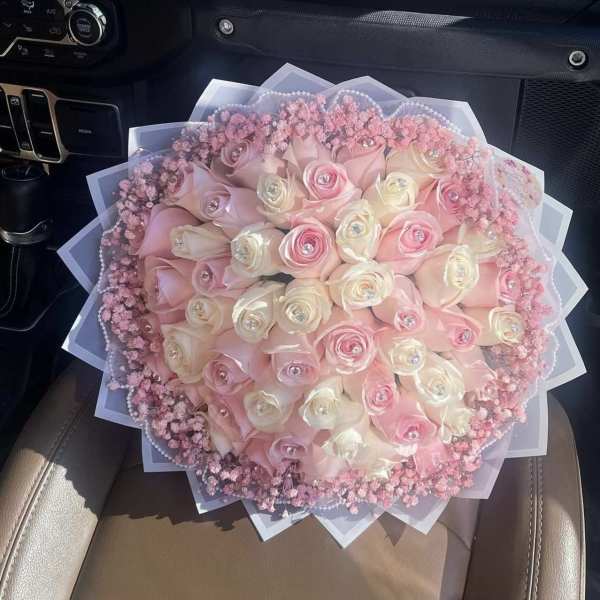 Round bouquet of pink and white roses with pink filler flowers