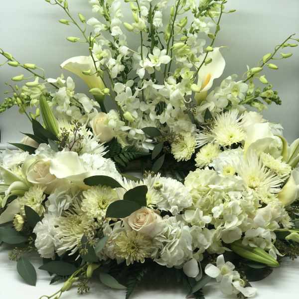 White floral arrangement with calla lilies, roses, orchids, and chrysanthemums