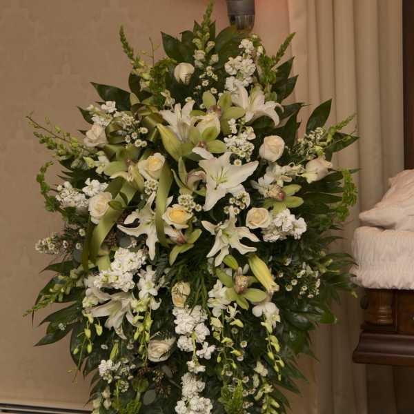 Large white floral standing spray with lilies and roses