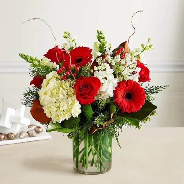 Red roses and gerbera daisies in a glass vase