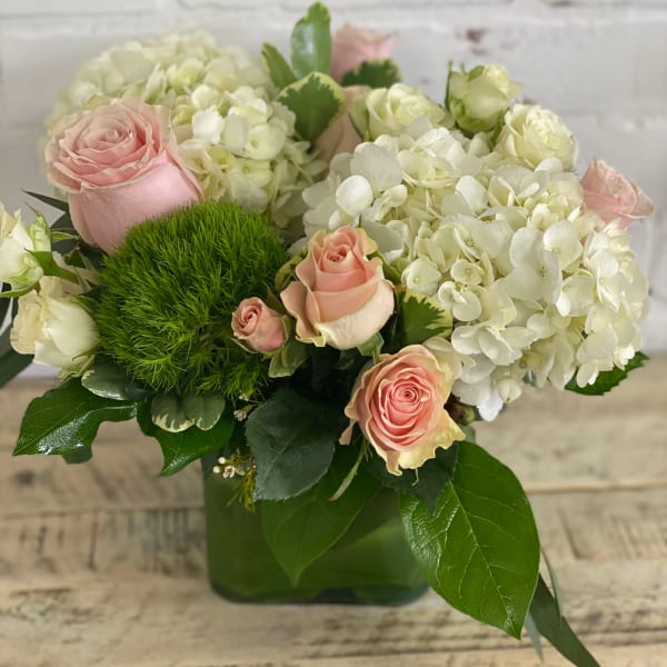 Pink roses and white hydrangeas in a green vase