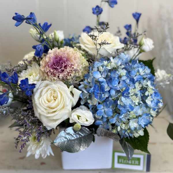 Blue and white floral arrangement in a white box