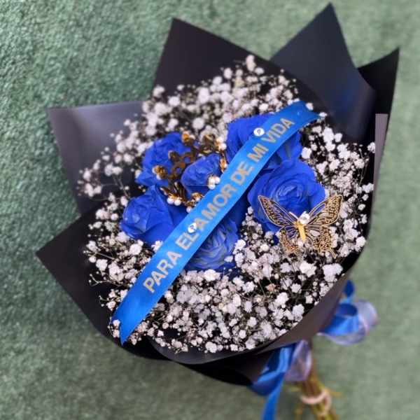 Blue roses in black wrap with baby's breath and a ribbon