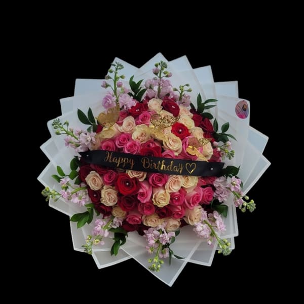 Bouquet of pink and red roses with a Happy Birthday sign