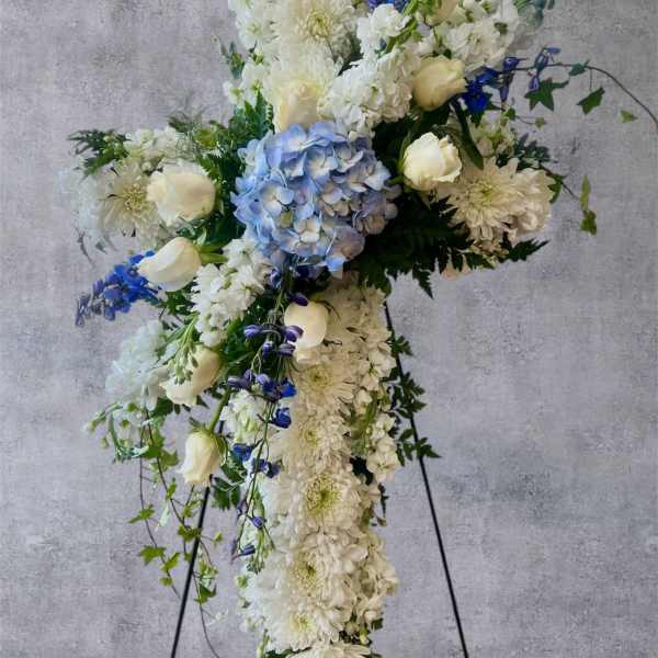 Large white and blue floral standing spray on an easel