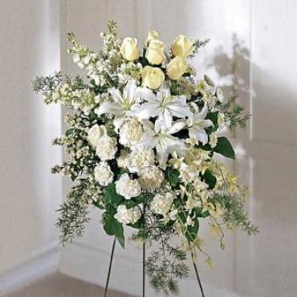White and pale yellow floral standing spray on a black easel