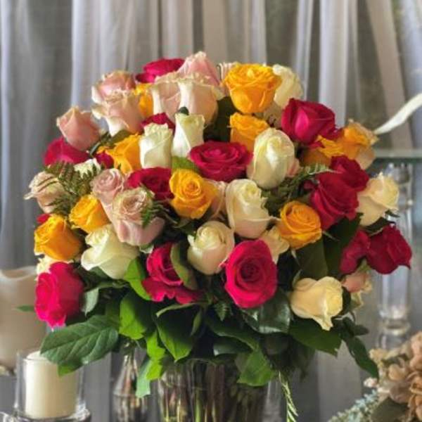 Large bouquet of multicolored roses in a clear glass vase
