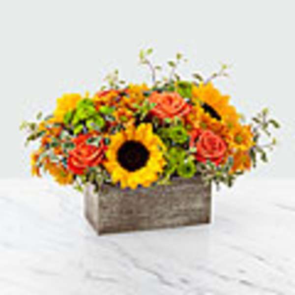Mixed bouquet with sunflowers and orange roses in a wooden box