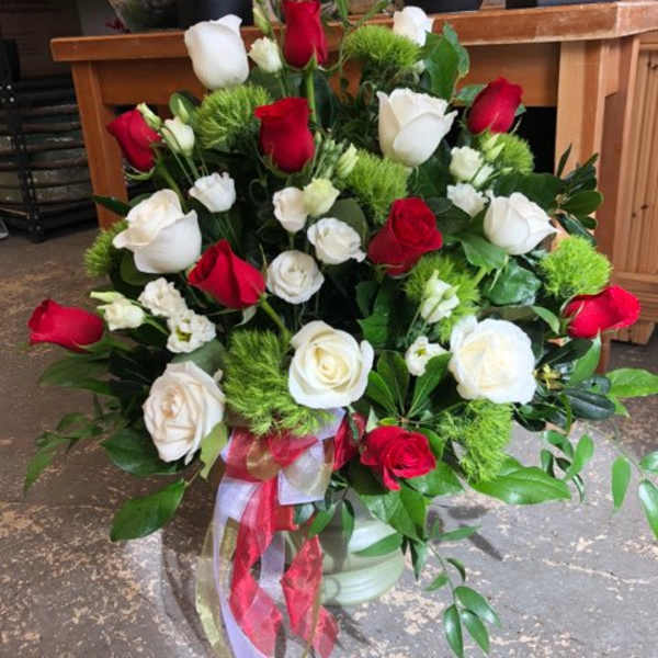 Bouquet of red and white roses with green accents and ribbon