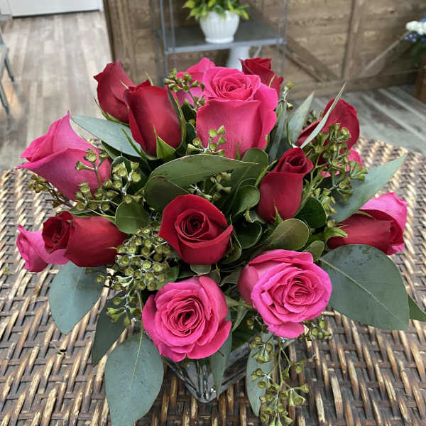 Bouquet of pink and red roses with eucalyptus in a glass vase