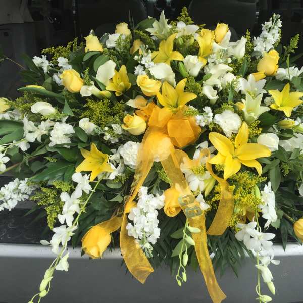 Yellow and white floral spray with ribbon on a vehicle tailgate