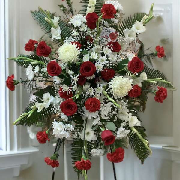 Standing floral spray with red roses, white flowers, and carnations