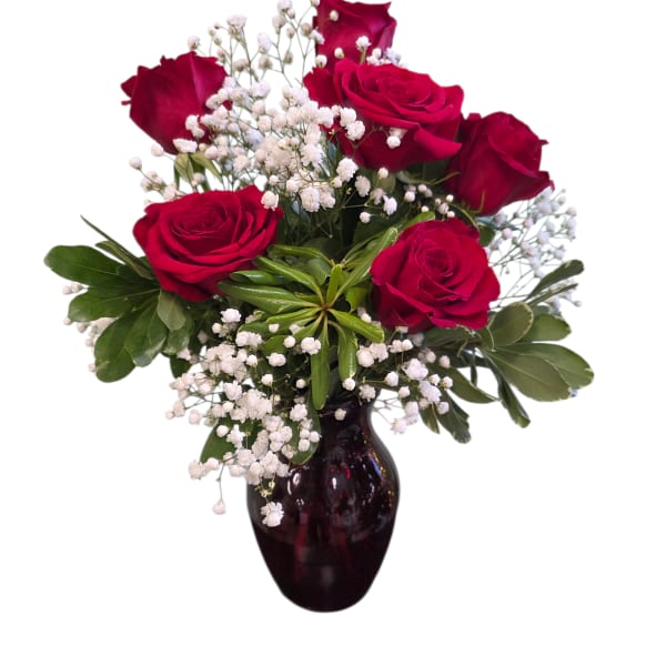 Red roses arranged in a dark glass vase with white baby's breath