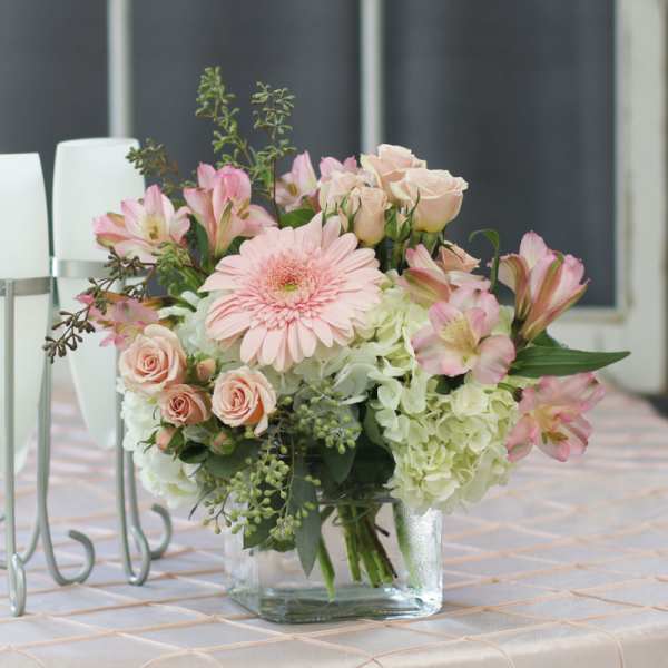 Pink and white floral arrangement in a clear glass vase