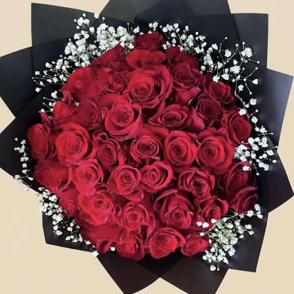 Bouquet of red roses with white baby's breath in black wrap