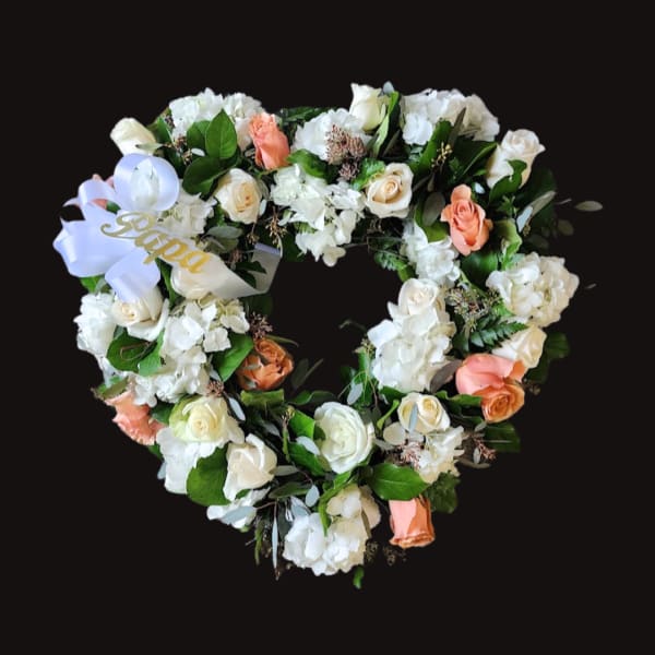 Heart-shaped floral wreath with white and peach roses