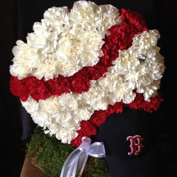 Red and white carnation arrangement shaped like a baseball cap