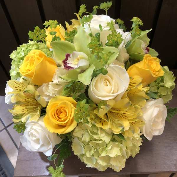Bouquet of yellow and white roses with green orchids and hydrangeas