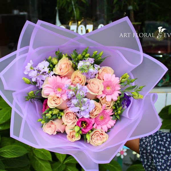 Lavender-wrapped bouquet of pink roses and gerbera daisies