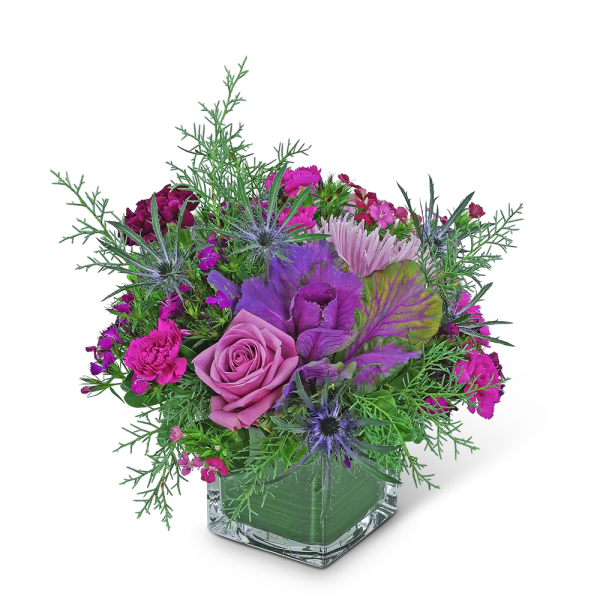 Pink and purple floral arrangement in a clear square vase