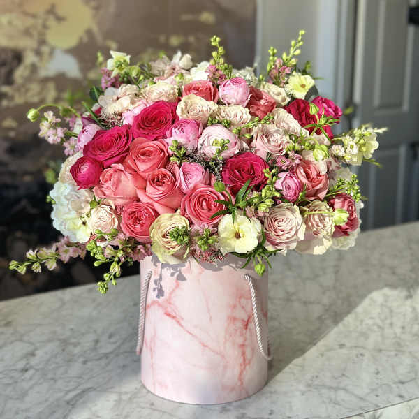 Pink and cream rose bouquet in a marble-patterned hat box