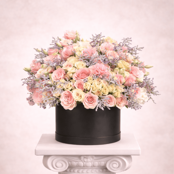 Round box arrangement of pink and cream roses