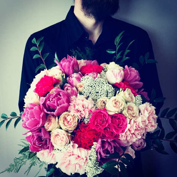Large bouquet of pink and white flowers held by a person