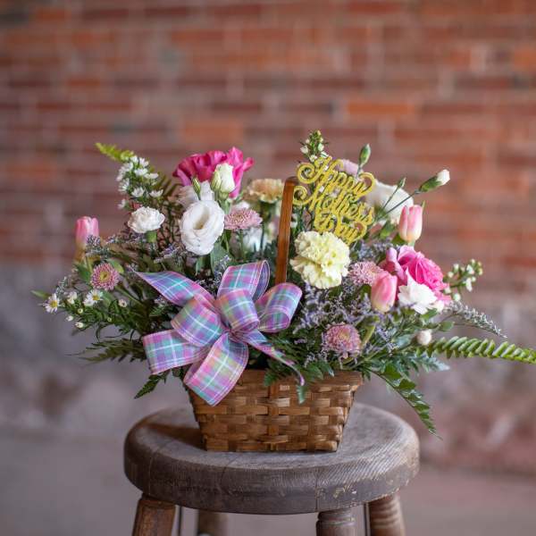 Basket arrangement of pink and white flowers with a Mother's Day pick
