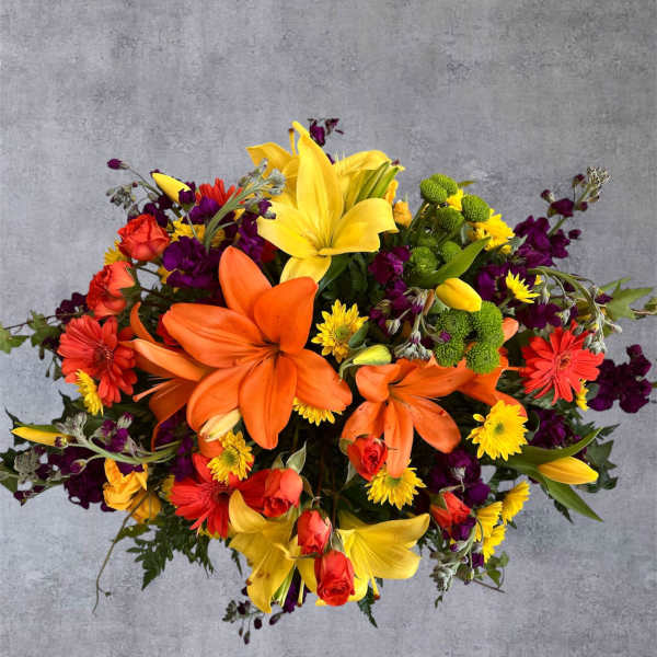 Bright mixed bouquet with yellow lilies, orange roses, and purple flowers