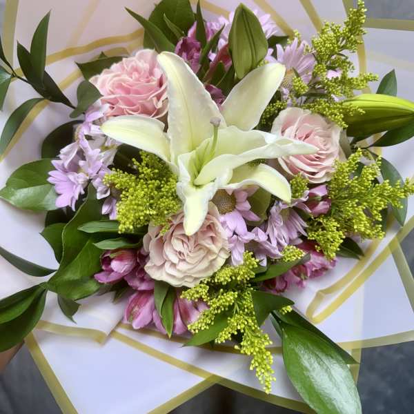 Bouquet of pink and white flowers wrapped in translucent paper